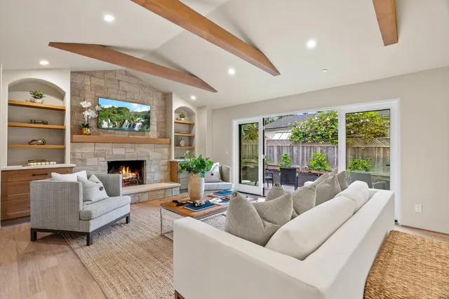 a living room with furniture a large window and a fireplace