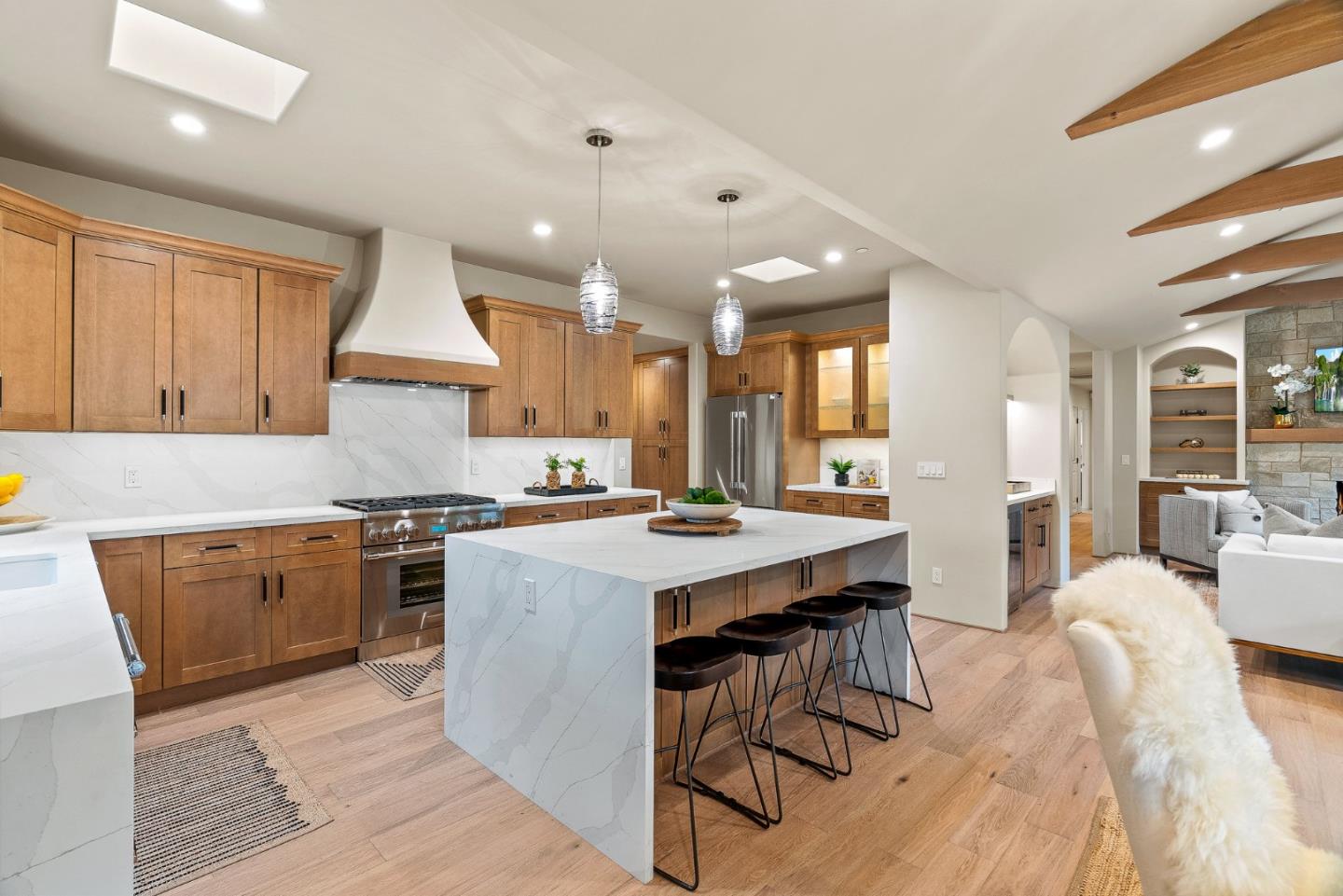 2869 Forest Lodge Road Pebble Beach, CA 93953 - Photo 9 of 34 a kitchen with stainless steel appliances granite countertop a stove a refrigerator a sink a dining table and chairs with wooden floor