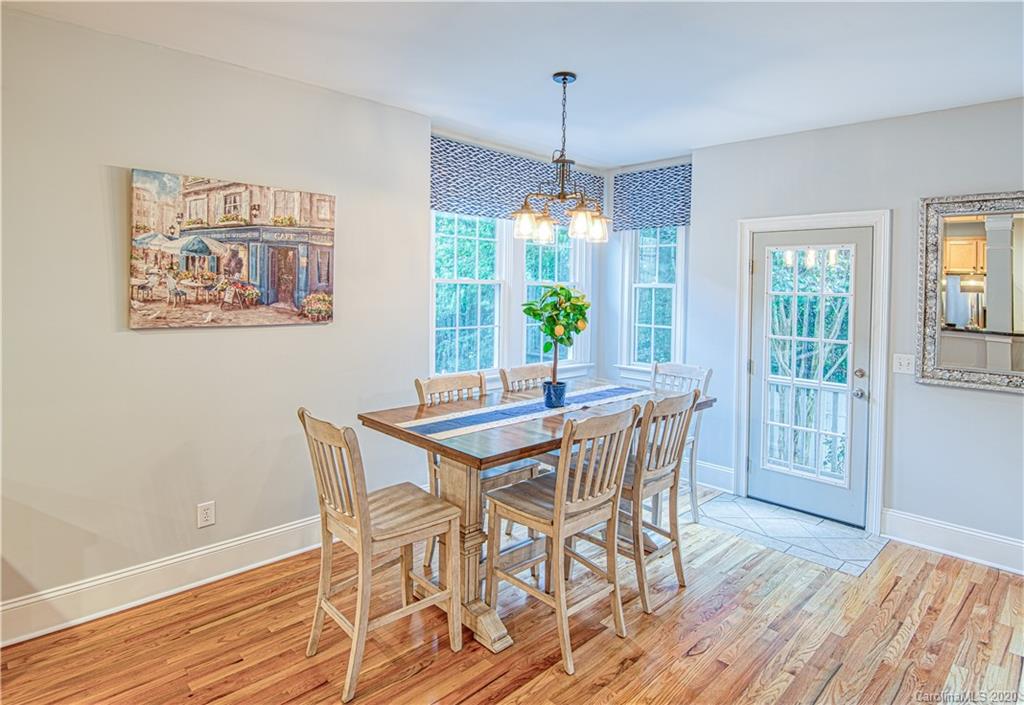 3224 Fifth Baxter Crossing Fort Mill, SC 29708 - Photo 11 of 41 a dining room with wooden floor a chandelier a wooden table and chairs