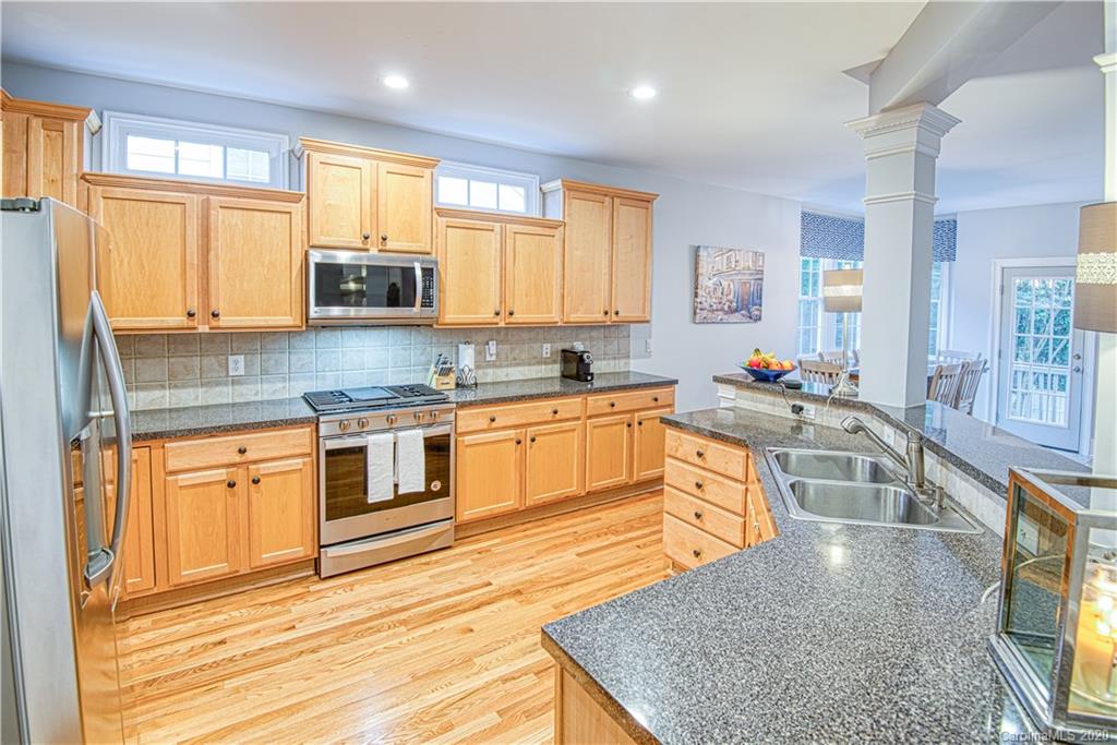 3224 Fifth Baxter Crossing Fort Mill, SC 29708 - Photo 7 of 41 a large kitchen with stainless steel appliances granite countertop a stove a sink dishwasher a microwave oven with cabinets and wooden floor