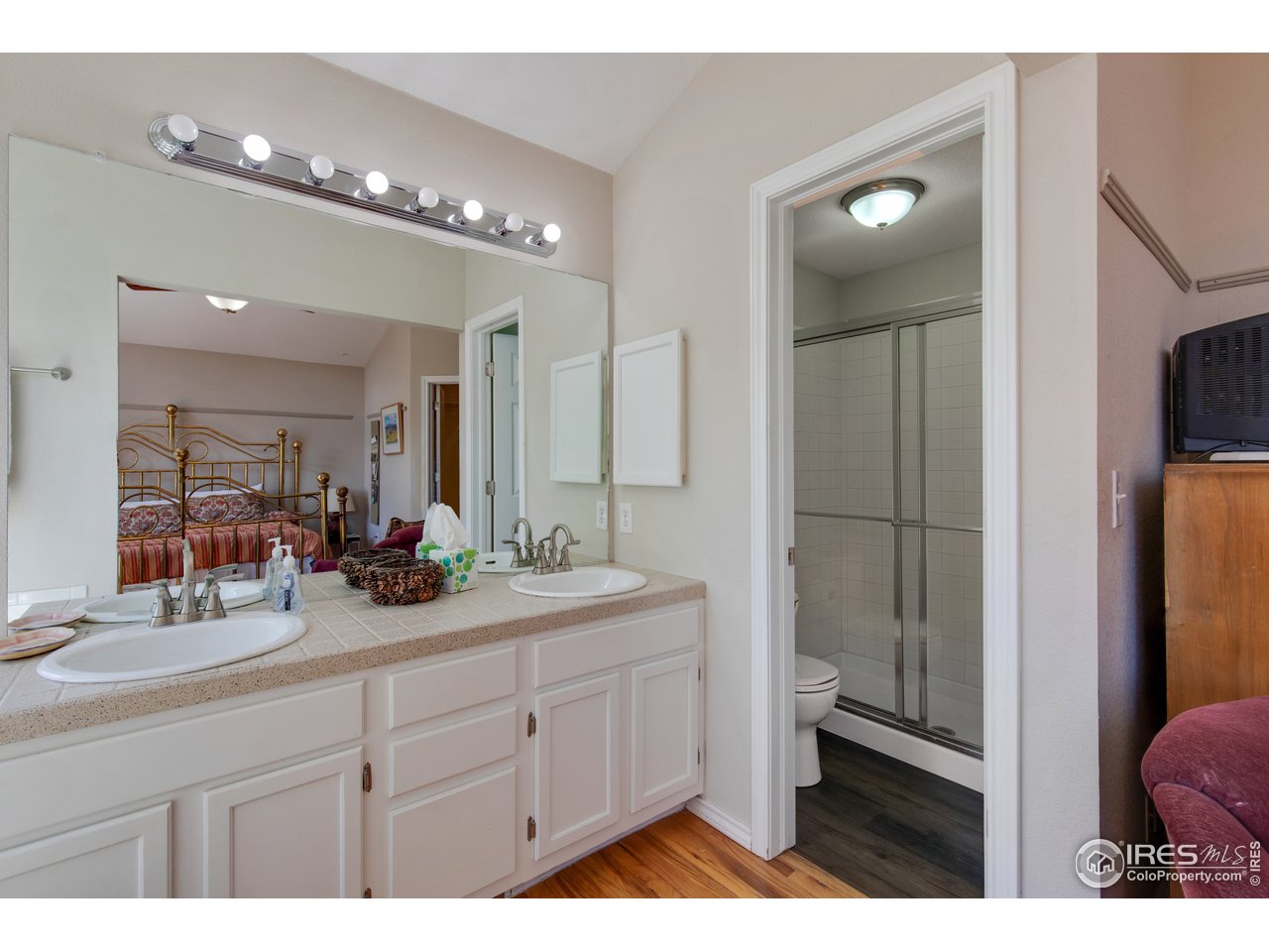 5635 Quarry Court Boulder, CO 80301 - Photo 13 of 28 a bathroom with a double vanity sink a toilet a mirror and shower