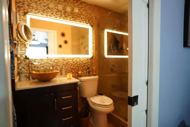a bathroom with a granite countertop toilet sink and mirror