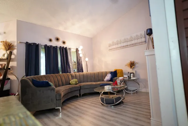 a living room with furniture and a wooden floor