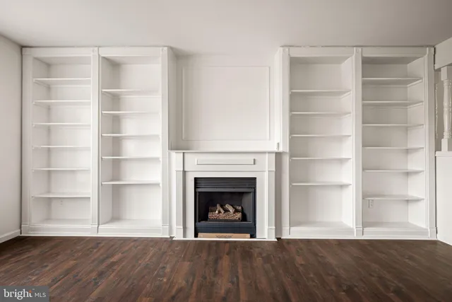 a view of an empty room with a fireplace and a window