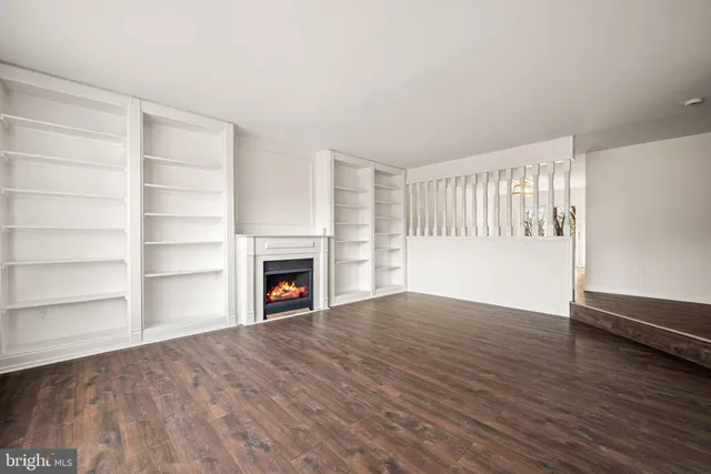 a view of an empty room with a fireplace and a window