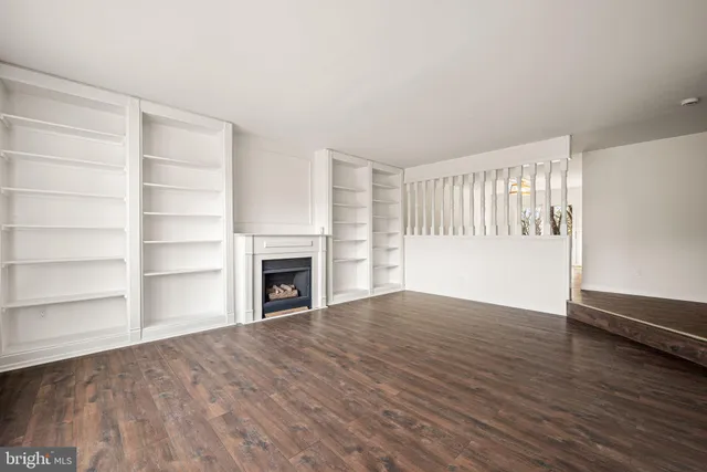 a view of an empty room with a fireplace and a window