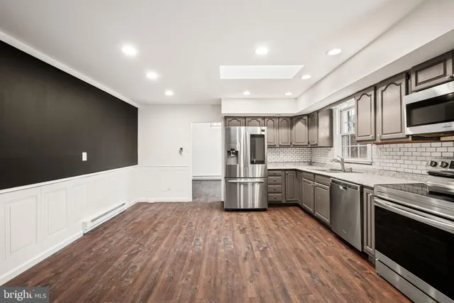 a kitchen with stainless steel appliances a refrigerator sink and microwave