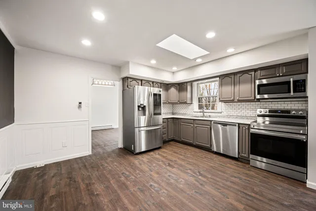 a kitchen with a refrigerator and a stove top oven