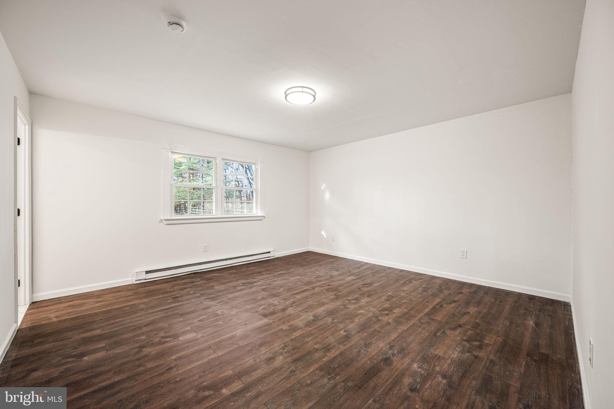 13 Keller Road Cochranville, PA 19330 - Photo 25 of 41 an empty room with wooden floor and windows