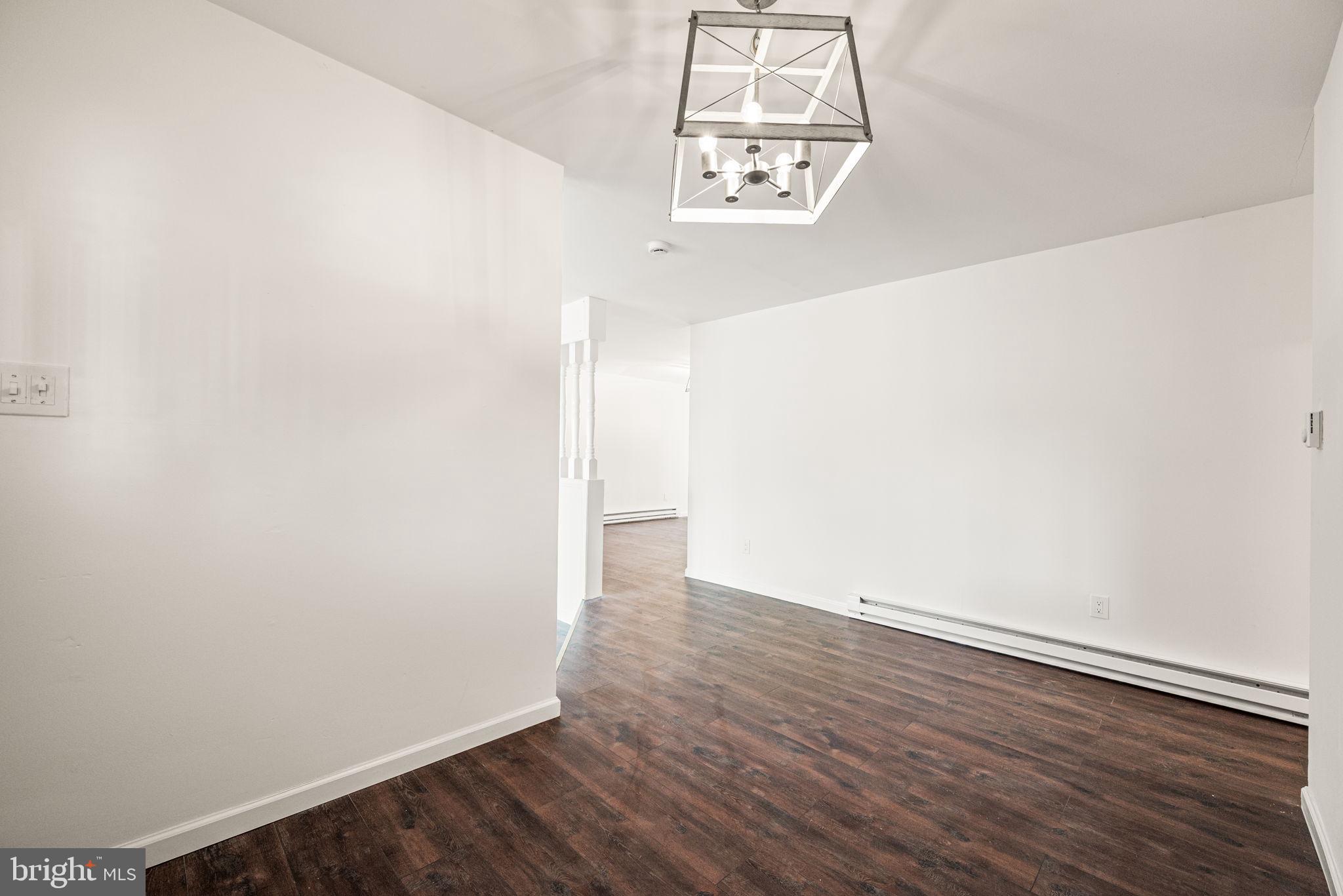 13 Keller Road Cochranville, PA 19330 - Photo 6 of 41 an empty room with wooden floor and chandelier