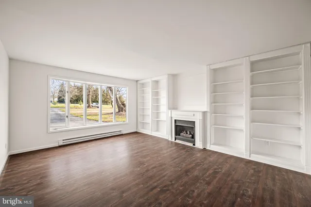 wooden floor fireplace and windows in an empty room