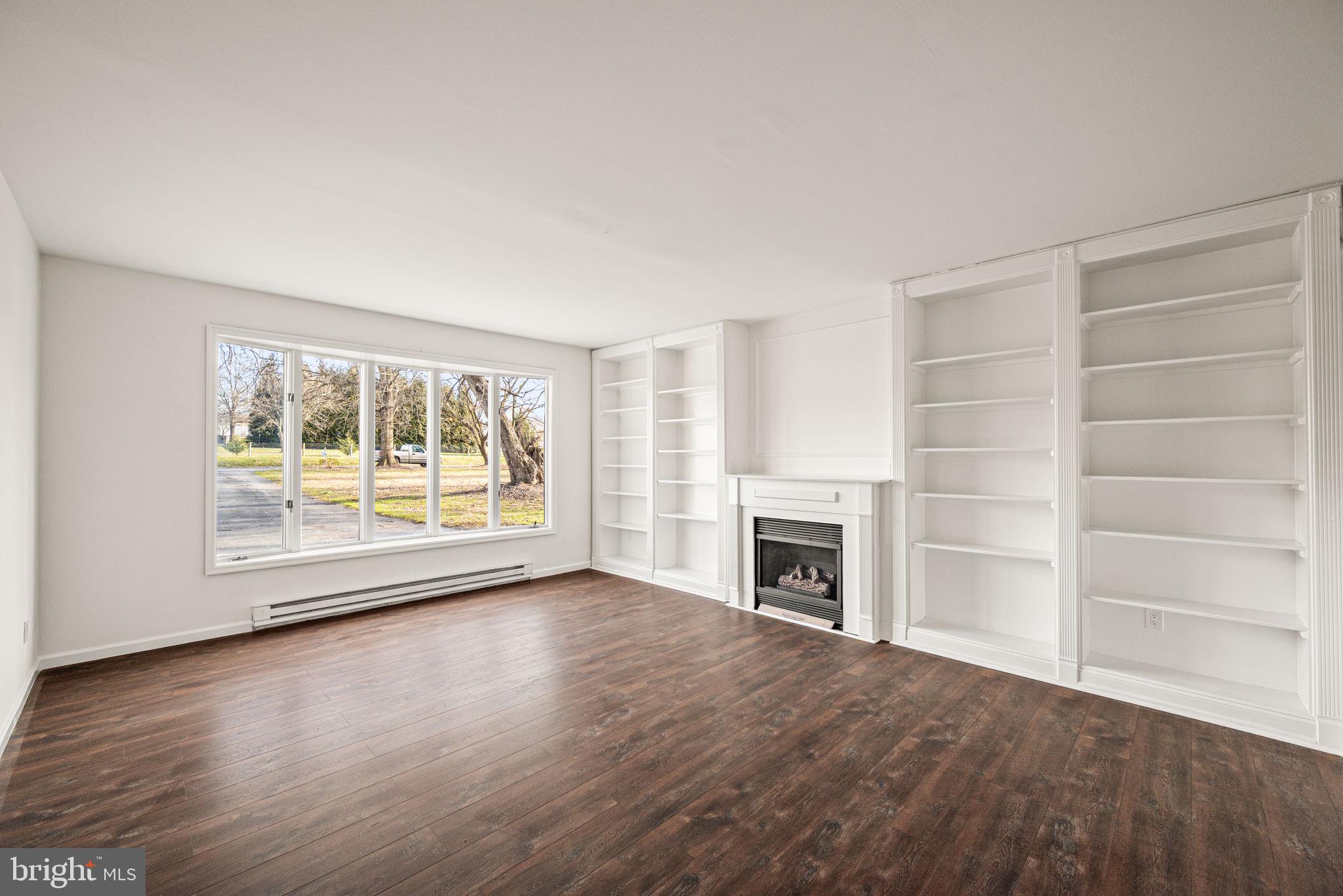 13 Keller Road Cochranville, PA 19330 - Photo 9 of 41 wooden floor fireplace and windows in an empty room