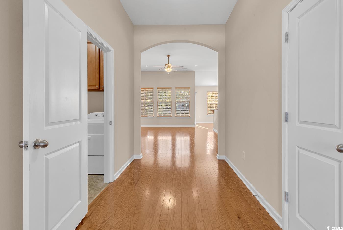 1612 Fairforest Court Conway, SC 29526 - Photo 4 of 40 Hallway with arched walkways, washer / clothes dryer, and light wood finished floors