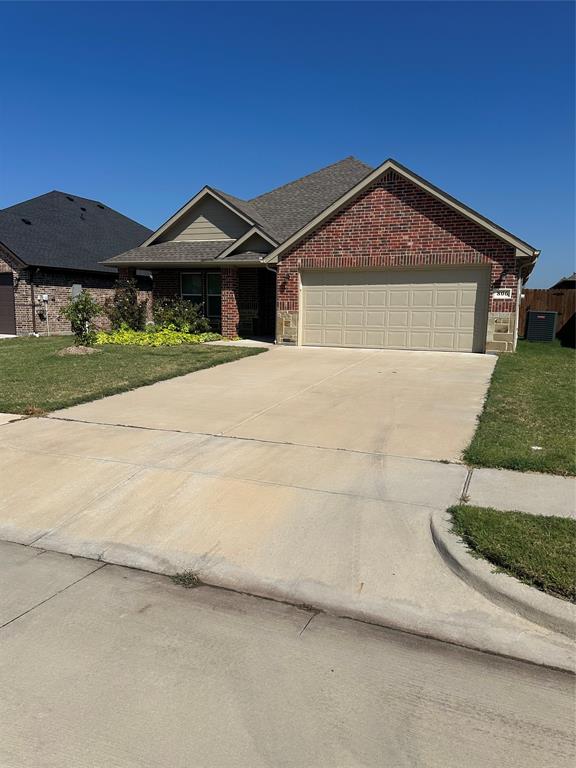 806 Ransom Way Greenville, TX 75402 - Photo 2 of 27 Brick exterior with stone accents, an attached garage, and a concrete driveway