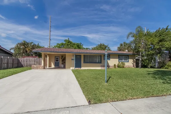 a front view of house with a garden