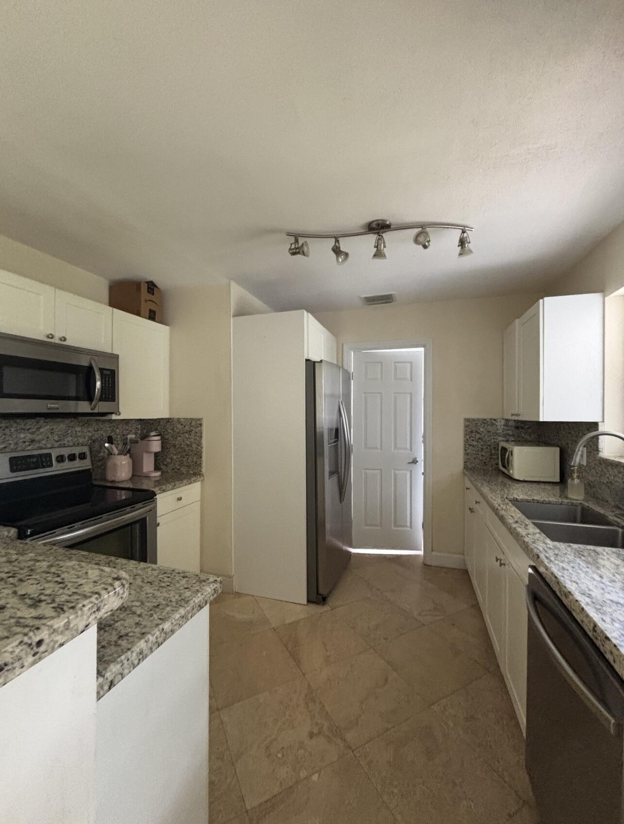 927 West Royal Palm Road Boca Raton, FL 33486 - Photo 11 of 31 a kitchen with a stove and a refrigerator