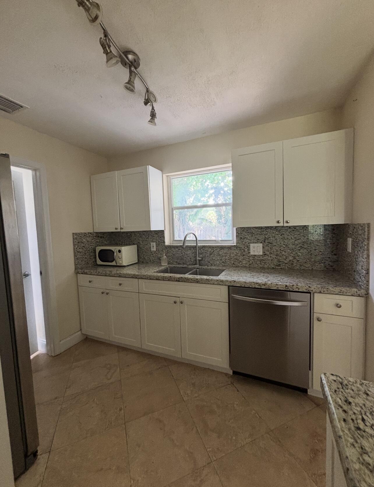 927 West Royal Palm Road Boca Raton, FL 33486 - Photo 12 of 31 a kitchen with granite countertop cabinets stainless steel appliances a sink and a window