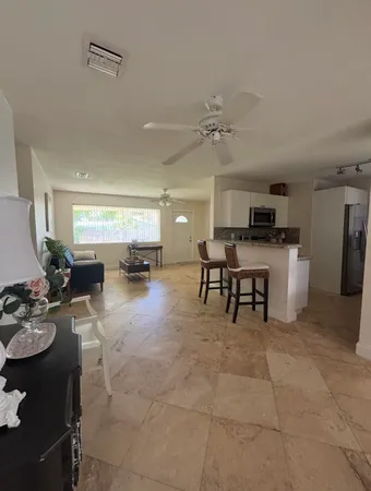 a living room with furniture and a dining table with kitchen view
