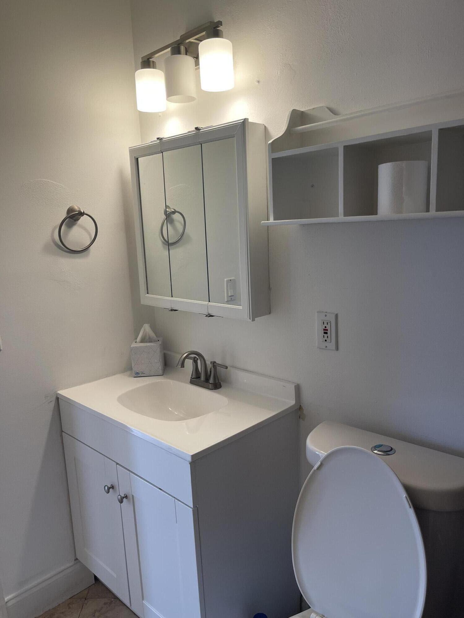 927 West Royal Palm Road Boca Raton, FL 33486 - Photo 18 of 31 a bathroom with a toilet sink and mirror