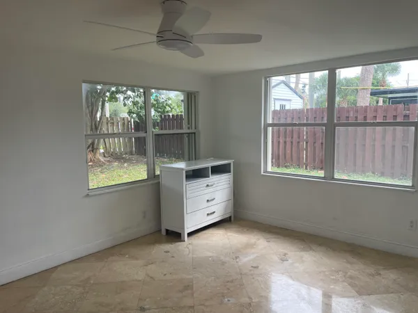 an empty room with windows and cabinet