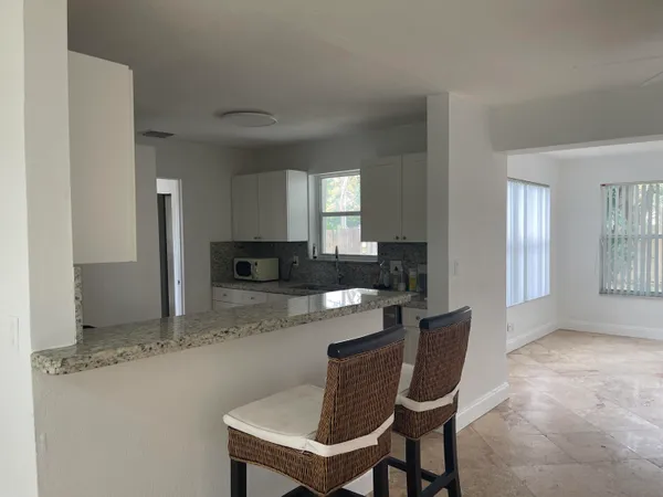 a kitchen with stainless steel appliances granite countertop a table and chairs in it