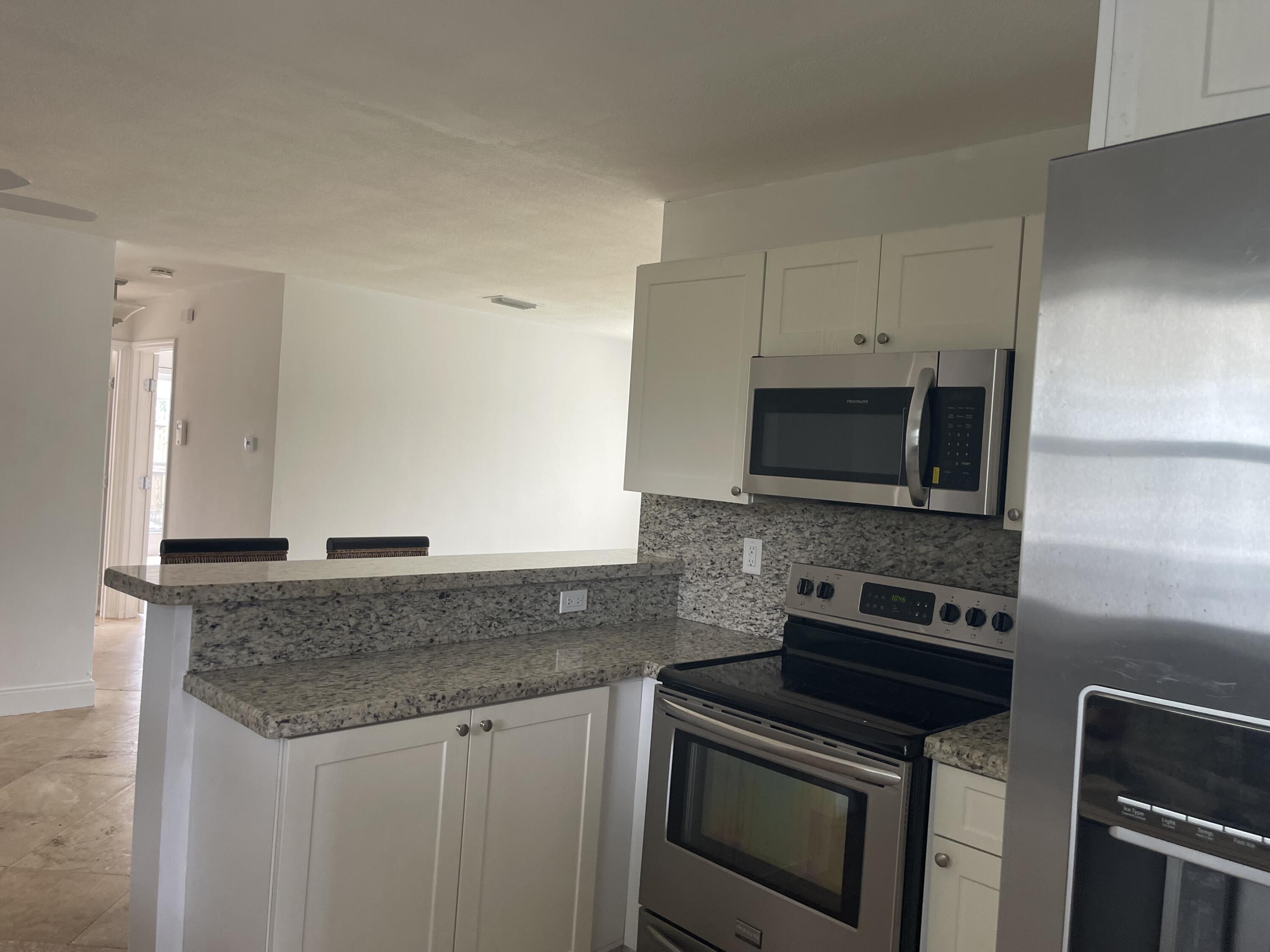 927 West Royal Palm Road Boca Raton, FL 33486 - Photo 7 of 31 a kitchen with granite countertop a sink stove and microwave