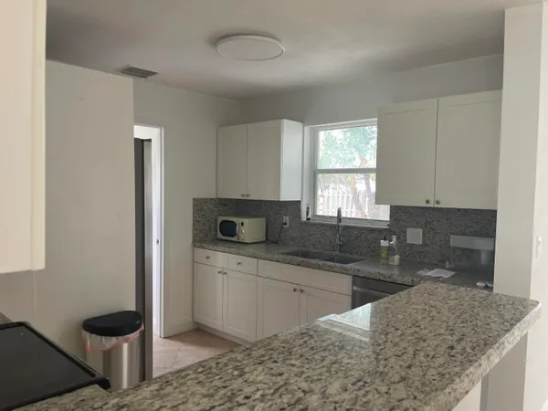a kitchen with stainless steel appliances granite countertop a sink stove and cabinets