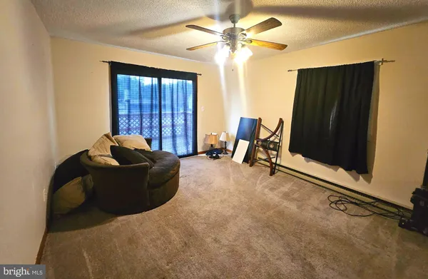a living room with furniture window and a ceiling fan