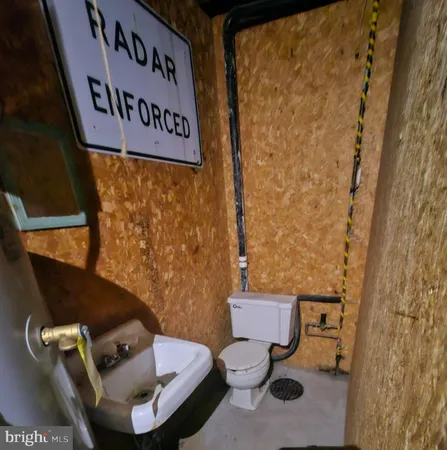 a toilet sitting next to a bathroom sink and a mirror