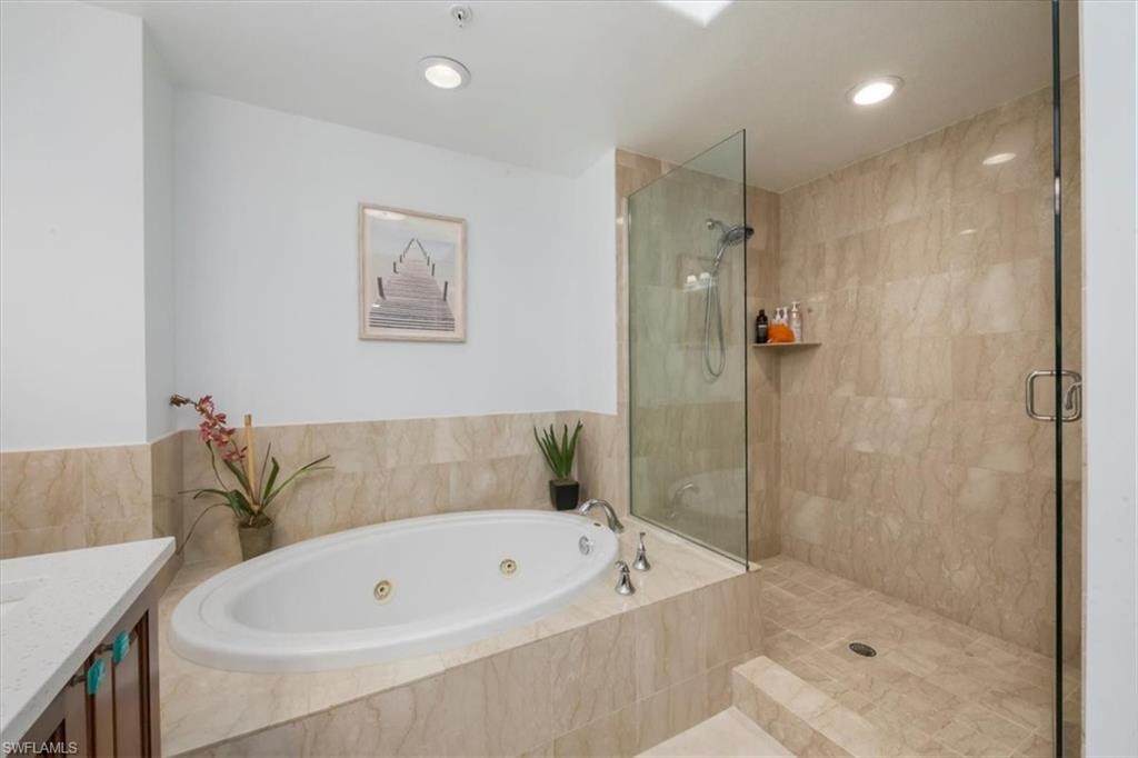 965 Sandpiper Street, Unit J107 Naples, FL 34102 - Photo 14 of 30 a bathroom with a tub a sink and a shower