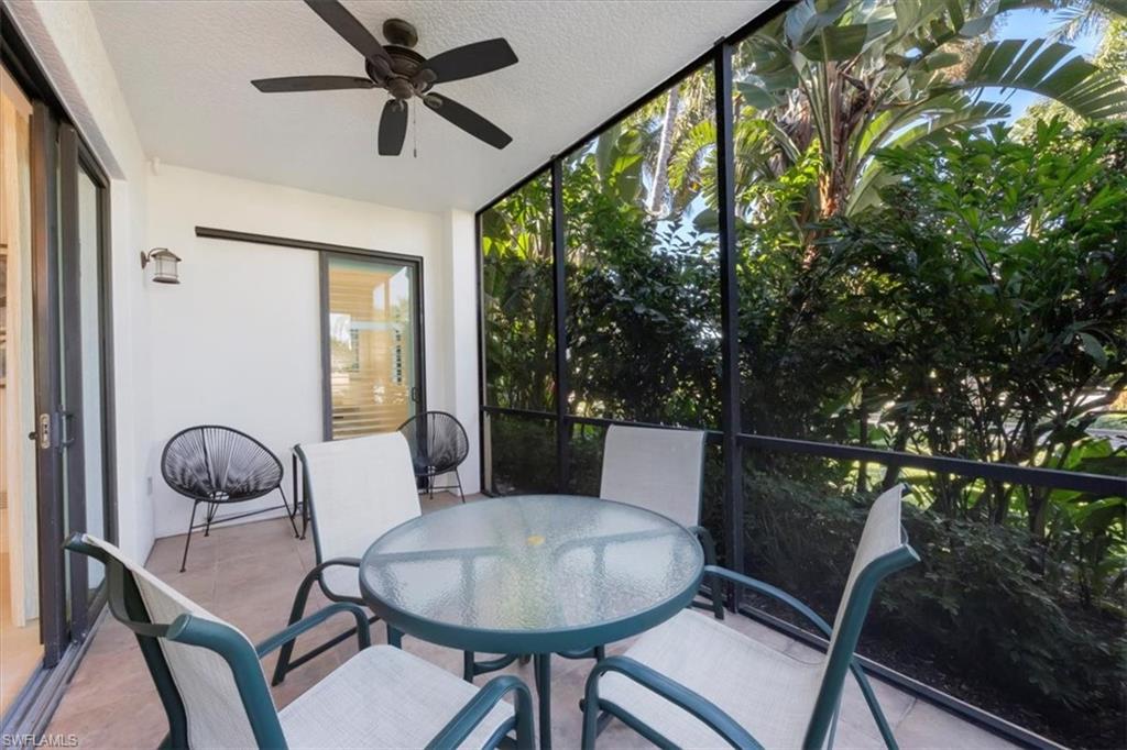 965 Sandpiper Street, Unit J107 Naples, FL 34102 - Photo 18 of 30 a dining room with furniture a chandelier and wooden floor