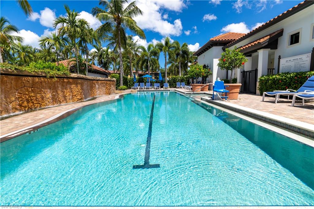 965 Sandpiper Street, Unit J107 Naples, FL 34102 - Photo 22 of 30 a swimming pool with outdoor seating and yard