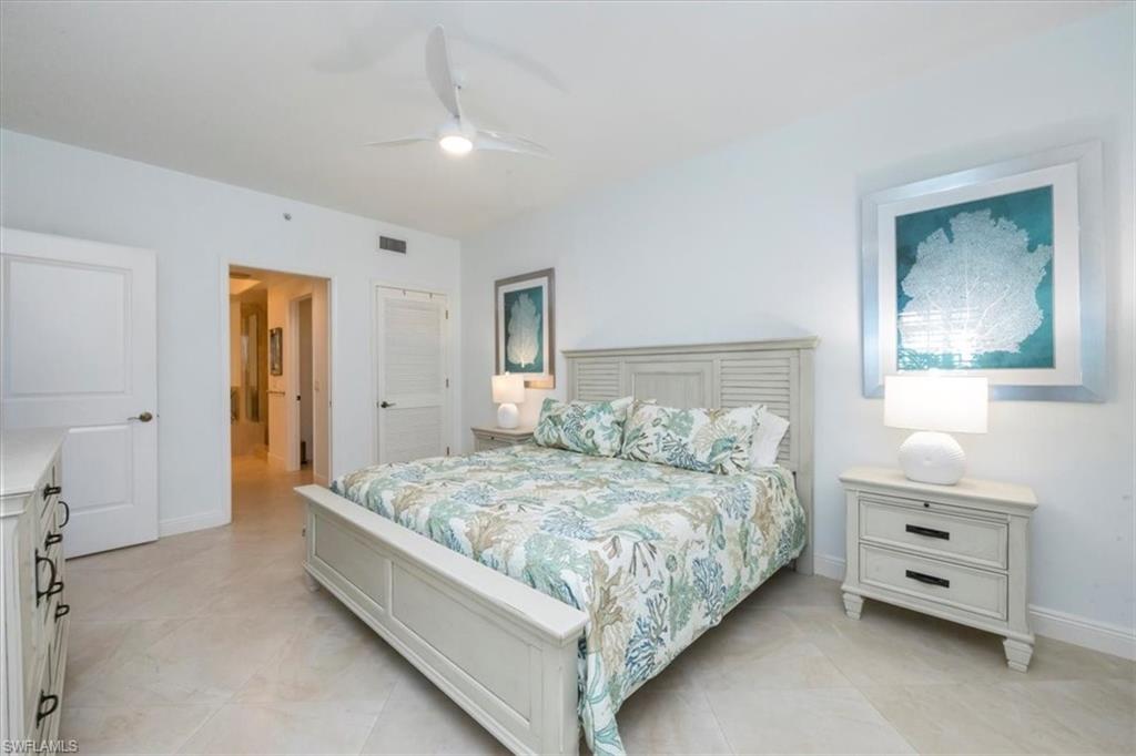 965 Sandpiper Street, Unit J107 Naples, FL 34102 - Photo 9 of 30 a bedroom with a bed and a dresser