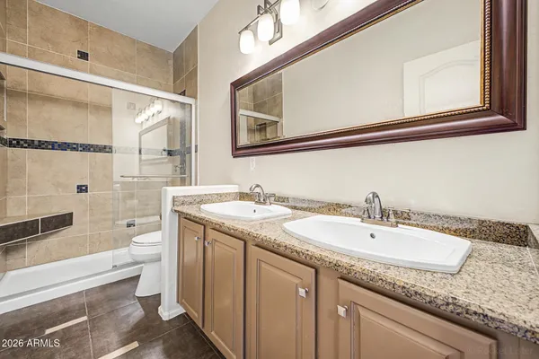 a bathroom with a granite countertop sink toilet and shower