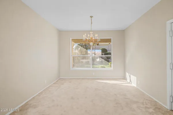 an empty room with windows and chandelier