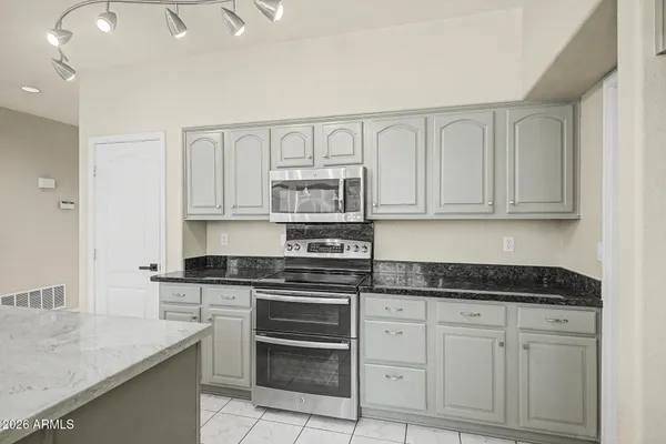 a kitchen with white cabinets and appliances
