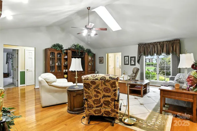 a living room with furniture chandelier and large windows