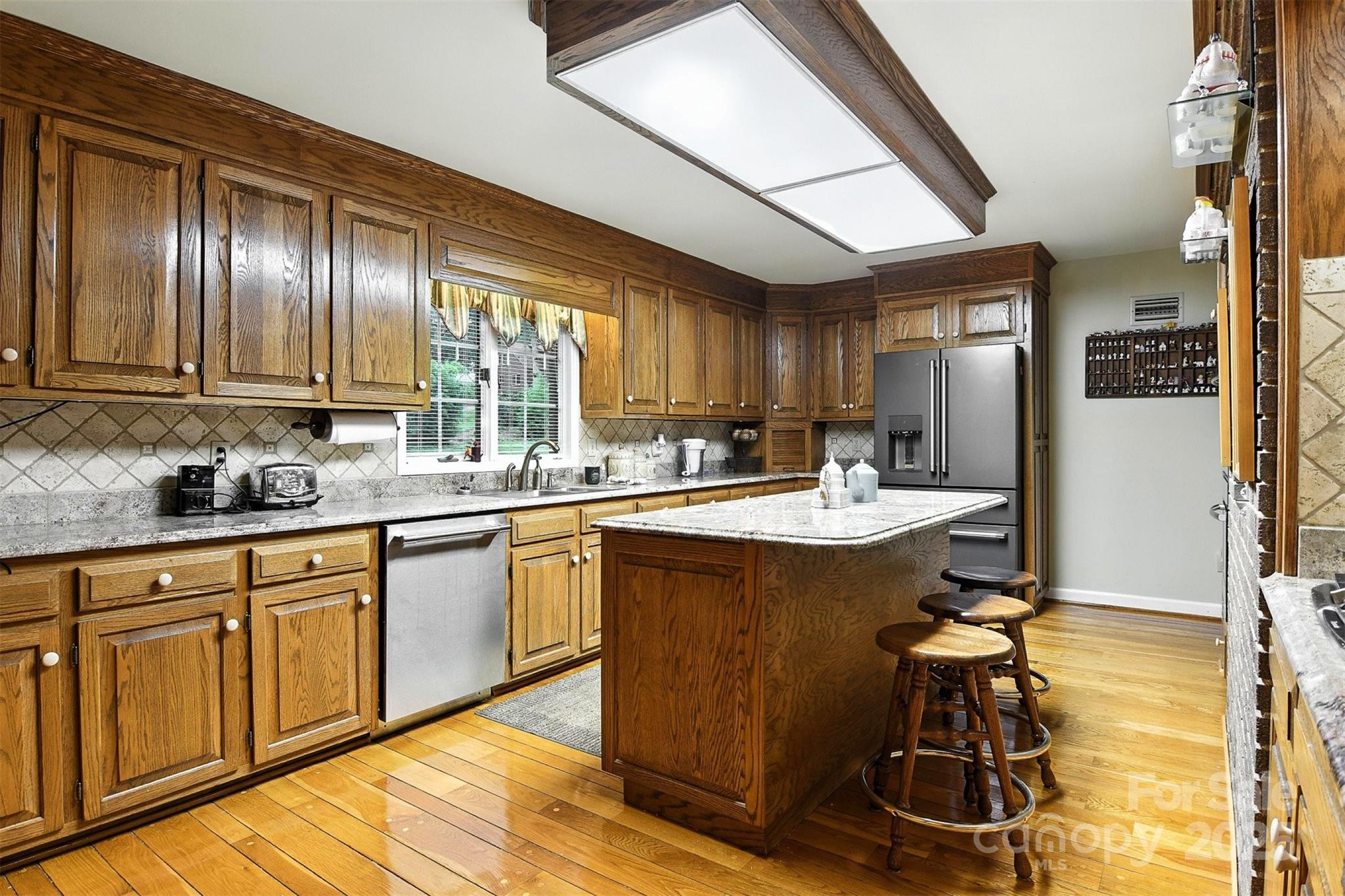 530 5th Street Northwest Hickory, NC 28601 - Photo 9 of 48 a kitchen with kitchen island granite countertop wooden cabinets stainless steel appliances a sink and a large window