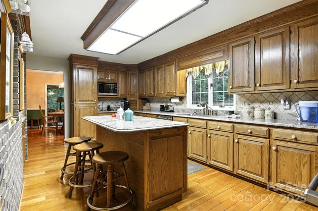 a kitchen with stainless steel appliances granite countertop a sink a stove and a refrigerator