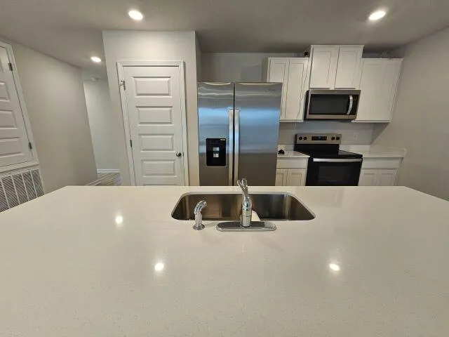 a kitchen with a refrigerator and a sink