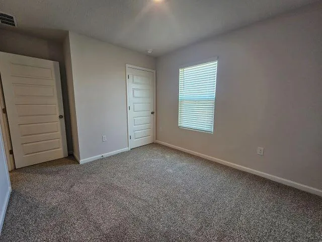 an empty room with closet and a window