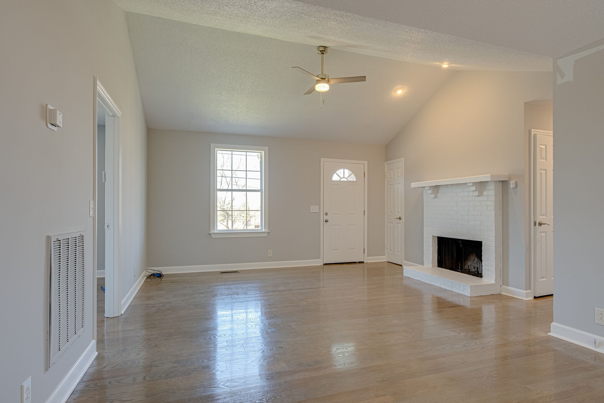 1108 Rural Hill Road Antioch, TN 37013 - Photo 2 of 16 an empty room with wooden floor fireplace and windows