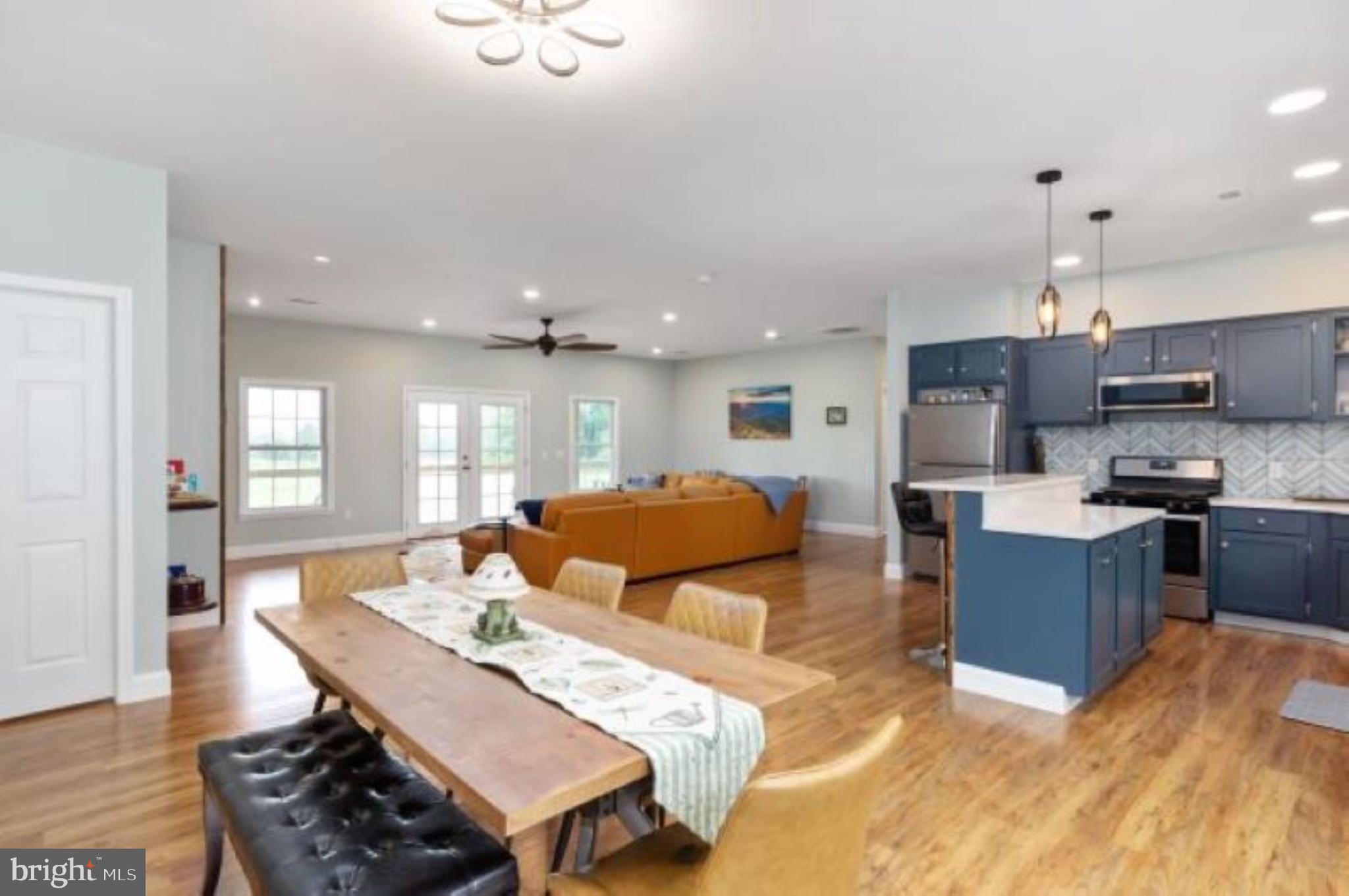 1195 Mountain View Drive Rileyville, VA 22650 - Photo 11 of 35 a kitchen with stainless steel appliances kitchen island granite countertop a refrigerator a stove a sink a dining table and chairs with wooden floor