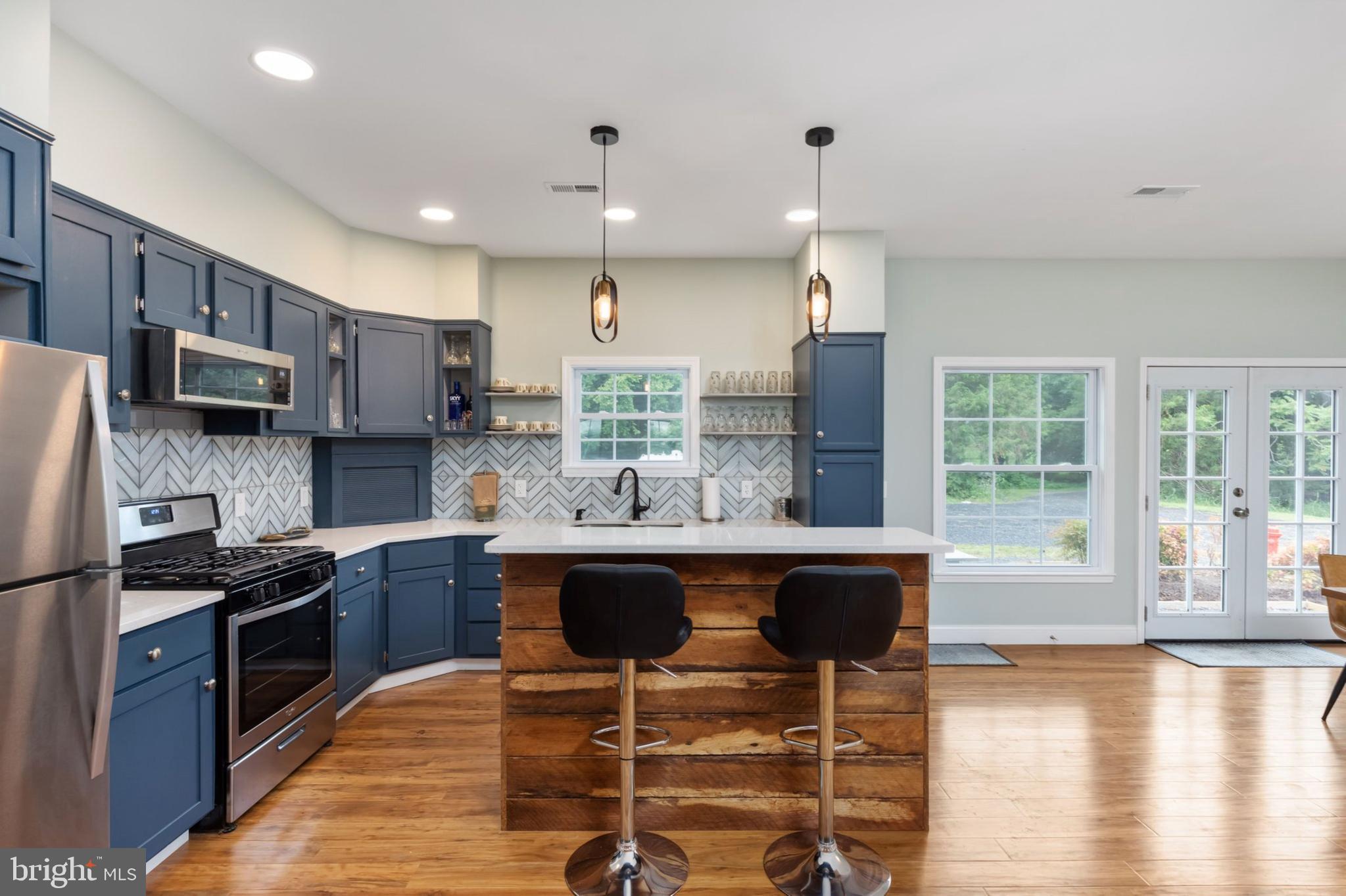 1195 Mountain View Drive Rileyville, VA 22650 - Photo 7 of 35 a kitchen with stainless steel appliances granite countertop a stove top oven a refrigerator a sink and a dining table with wooden floor