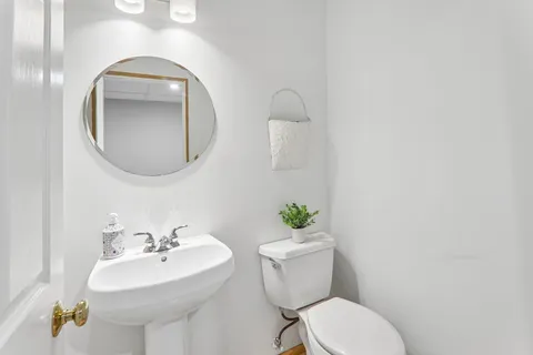 a bathroom with a toilet sink and mirror