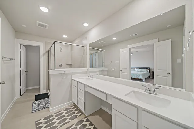 a bathroom with a sink mirror and a shower
