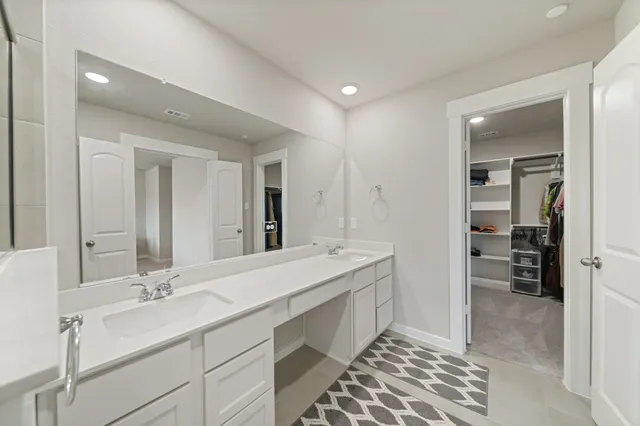 a spacious bathroom with a double vanity sink and a mirror