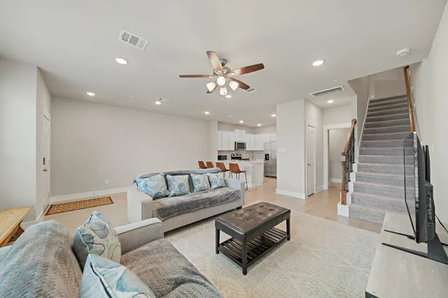a living room with furniture and a ceiling fan