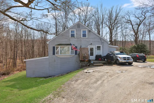 a view of a house with a patio and a yard