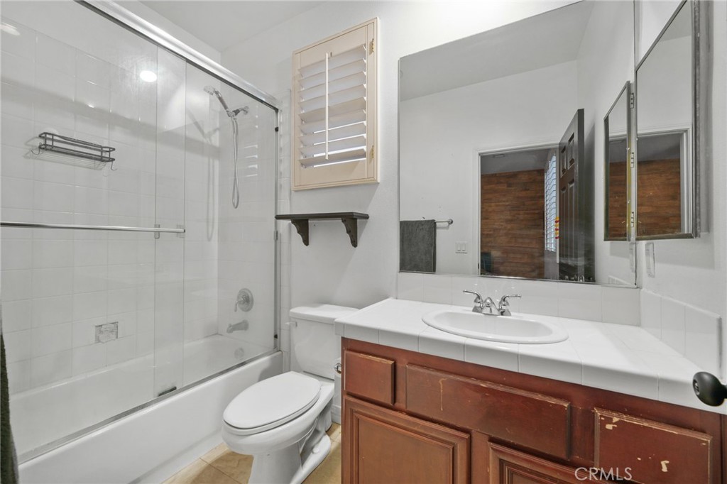 18604 Sunset Knoll Drive Riverside, CA 92504 - Photo 23 of 66 a bathroom with a sink toilet a mirror and shower